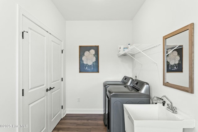 laundry room with baseboards, a sink, laundry area, dark wood-style floors, and washing machine and clothes dryer