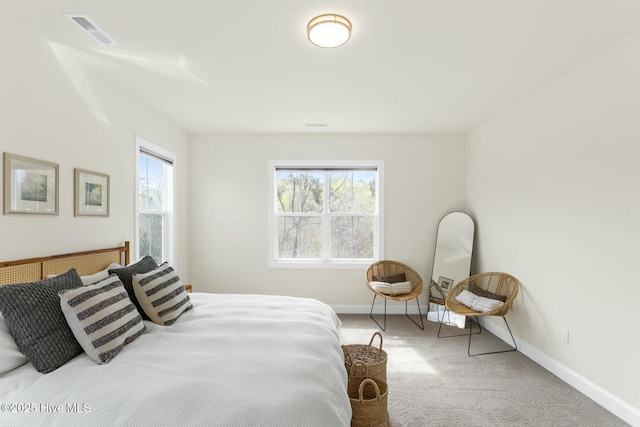 carpeted bedroom featuring baseboards and visible vents