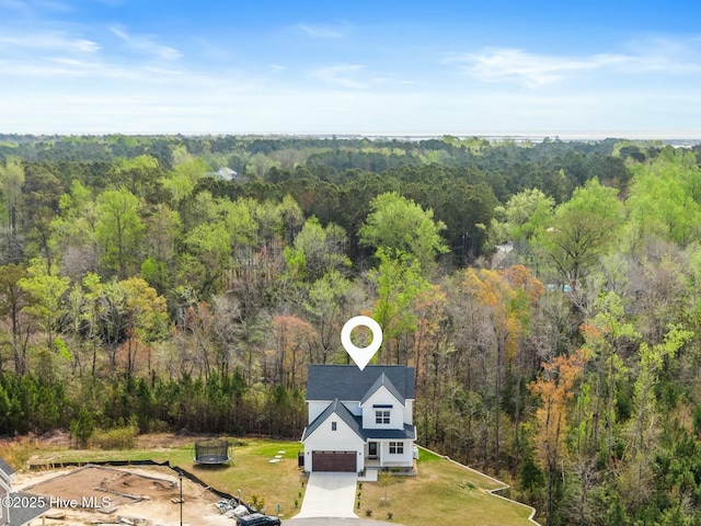 drone / aerial view featuring a wooded view
