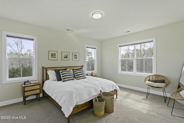 carpeted bedroom featuring baseboards and visible vents
