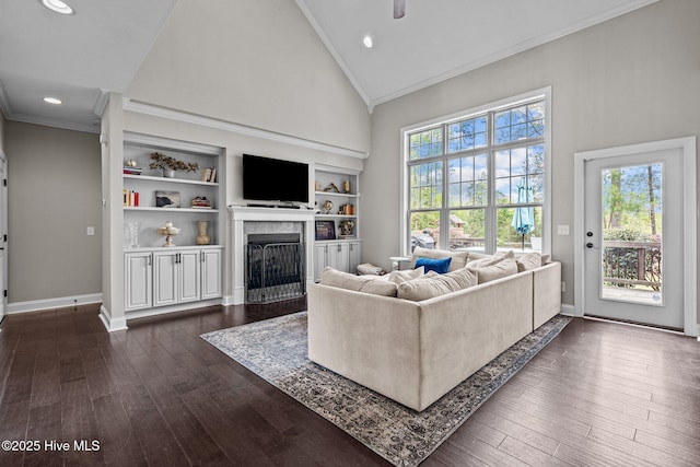 living room featuring a high end fireplace, dark wood-style floors, crown molding, recessed lighting, and high vaulted ceiling