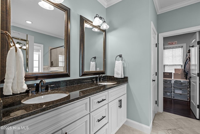 full bath with a sink, double vanity, and crown molding