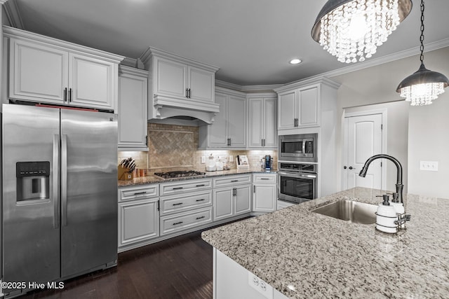 kitchen featuring recessed lighting, a chandelier, appliances with stainless steel finishes, a sink, and custom range hood