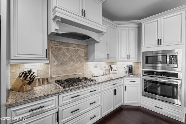 kitchen with custom range hood, white cabinets, and stainless steel appliances