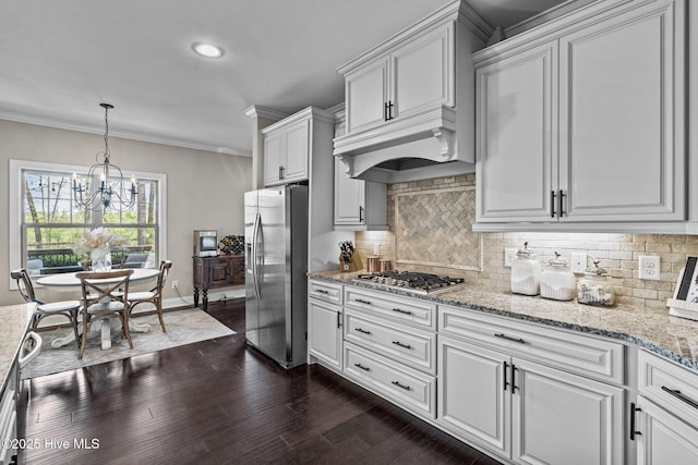 kitchen with ornamental molding, decorative backsplash, white cabinetry, and stainless steel appliances