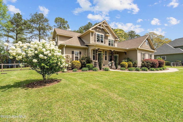 craftsman house featuring a porch, a front lawn, and roof with shingles