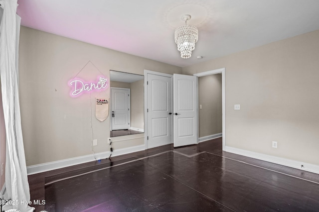empty room with baseboards and an inviting chandelier