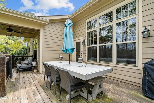 wooden terrace with outdoor dining space and ceiling fan