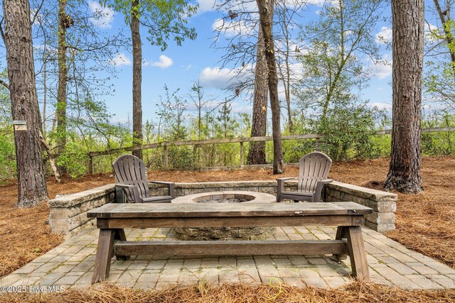 view of patio featuring an outdoor fire pit and fence