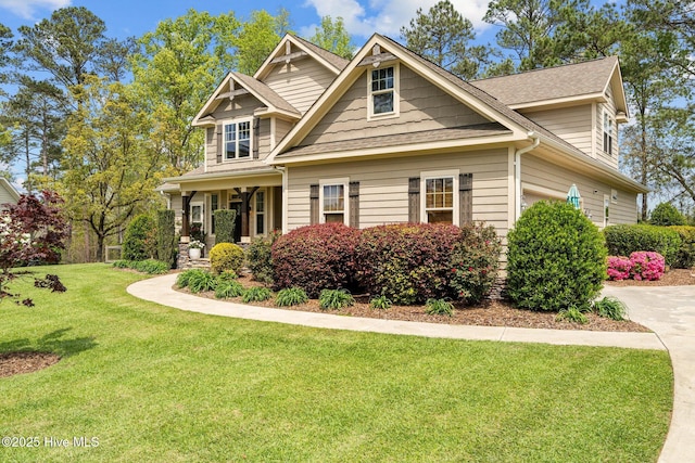 craftsman inspired home with a shingled roof and a front lawn