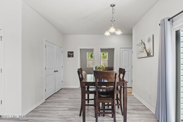 dining space with light wood-style flooring and baseboards