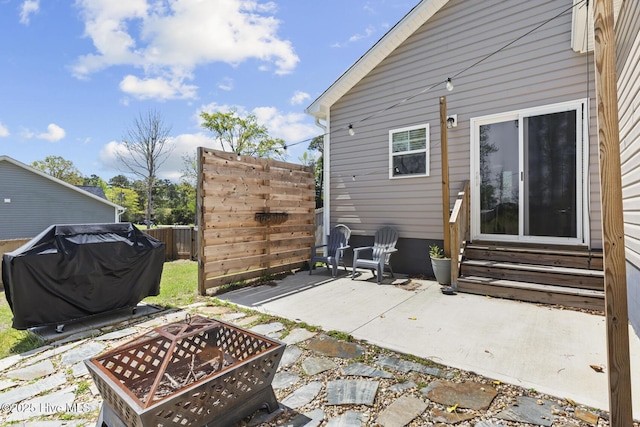 back of house with entry steps, fence, a fire pit, and a patio