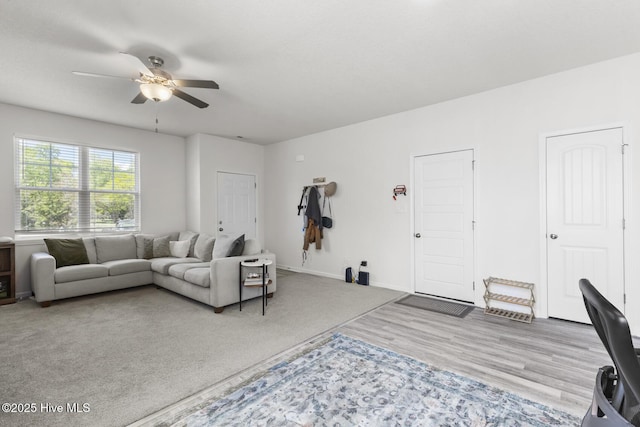 living room featuring baseboards, a ceiling fan, and wood finished floors