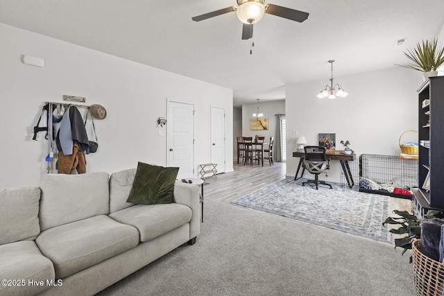 living room with visible vents, ceiling fan with notable chandelier, and carpet floors