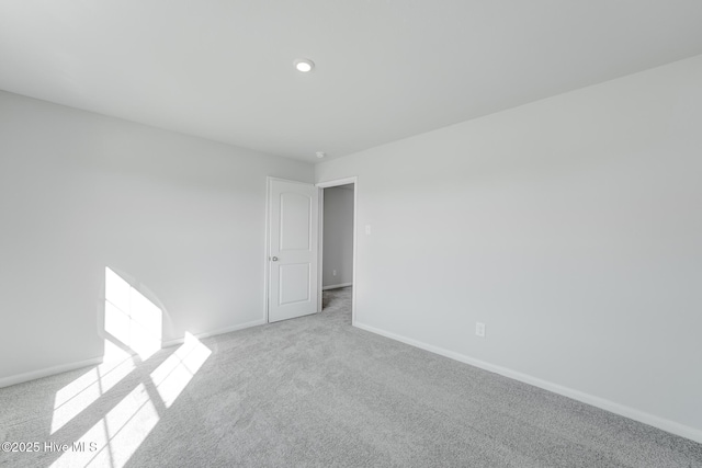 carpeted spare room featuring baseboards and recessed lighting