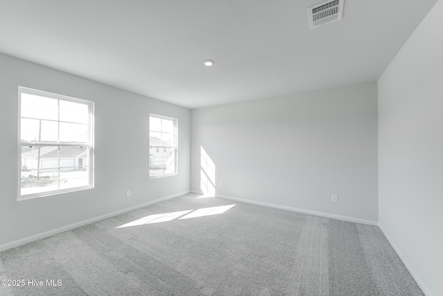 unfurnished room with recessed lighting, carpet flooring, visible vents, and baseboards