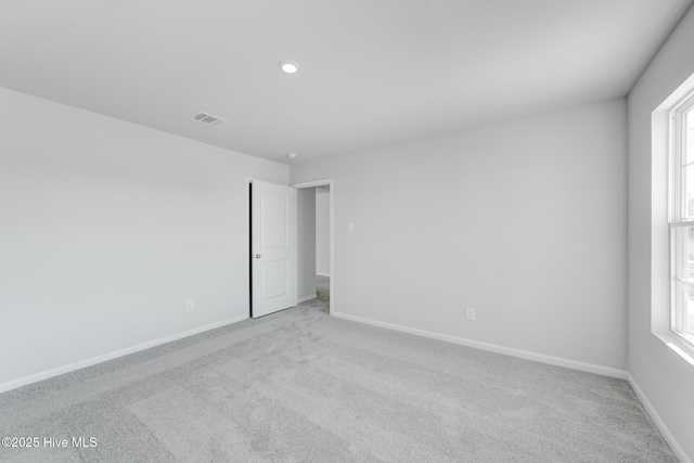 carpeted spare room featuring recessed lighting, visible vents, baseboards, and a healthy amount of sunlight
