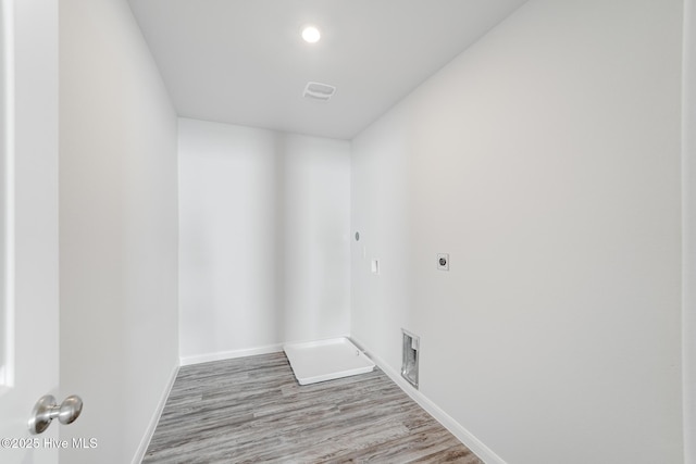 clothes washing area featuring baseboards, electric dryer hookup, visible vents, laundry area, and wood finished floors