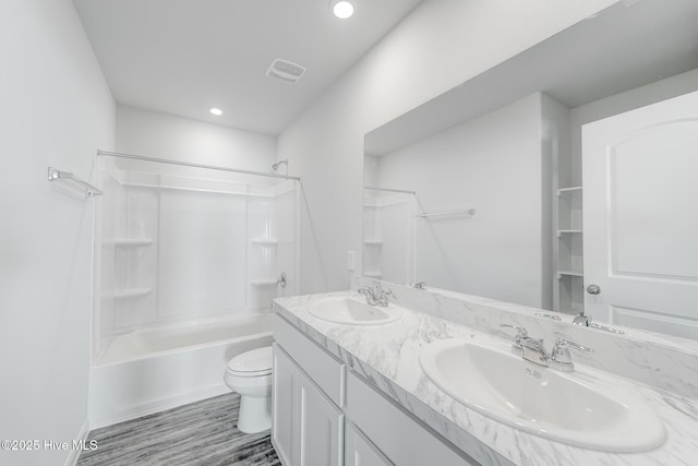 full bathroom with a sink, visible vents, toilet, and shower / bathing tub combination