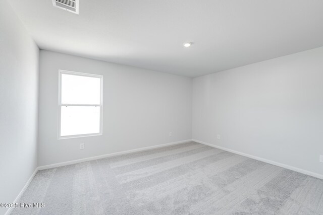spare room featuring visible vents, baseboards, and carpet floors