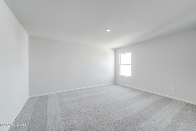 empty room with baseboards, recessed lighting, and carpet