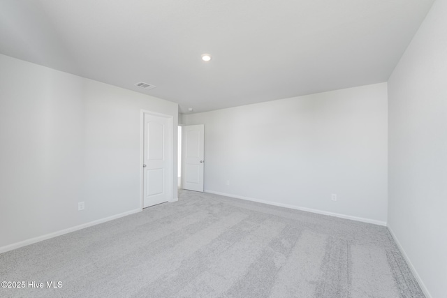 carpeted spare room featuring baseboards, visible vents, and recessed lighting