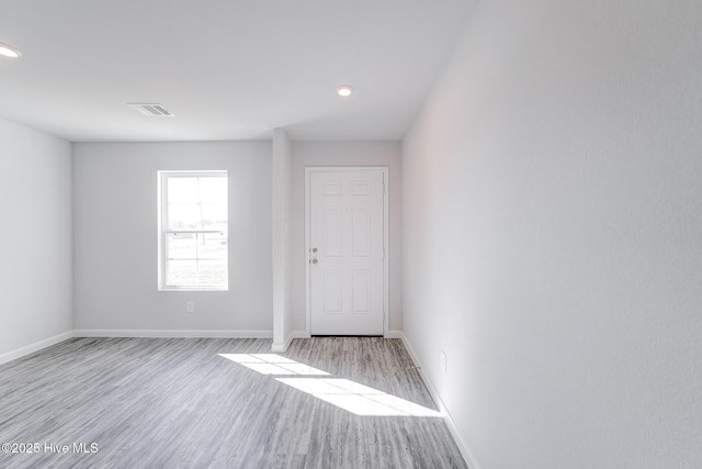 empty room featuring recessed lighting, visible vents, baseboards, and wood finished floors