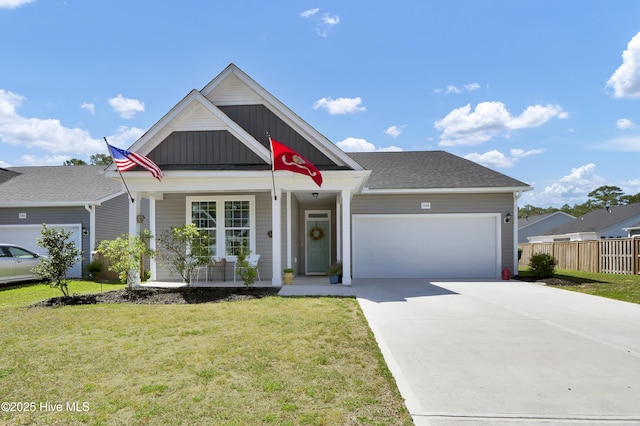 view of front facade featuring a front lawn, driveway, an attached garage, fence, and a porch
