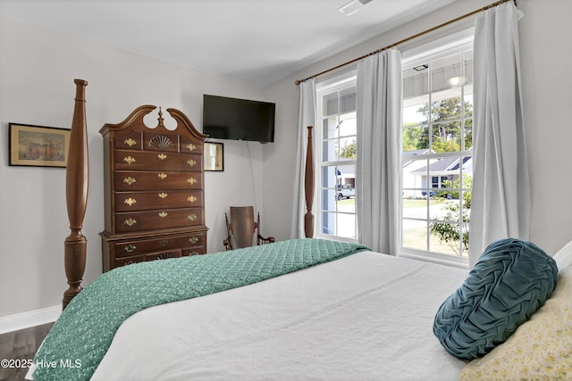 bedroom with dark wood finished floors and baseboards