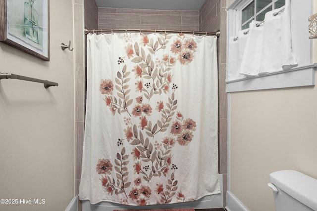 1508 Rhem Ave, New Bern, NC 28560 - bathroom featuring toilet, shower / tub combo with curtain, and baseboards
