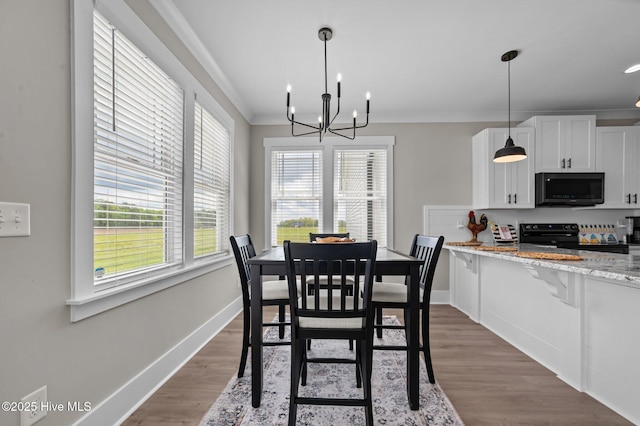 1004 Winfield Ln, Pinetown, NC 27865 - dining space with a chandelier, dark wood finished floors, baseboards, and ornamental molding