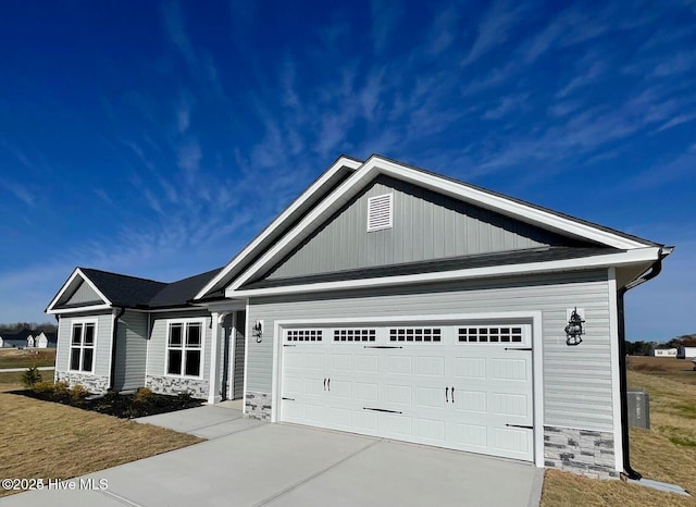 single story home featuring an attached garage, driveway, and stone siding