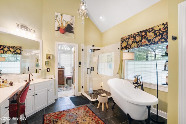 bathroom with a stall shower, a freestanding bath, lofted ceiling, and vanity