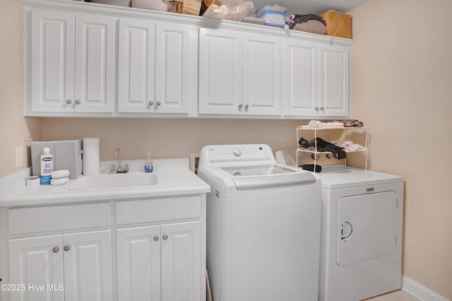 washroom with independent washer and dryer, a sink, and cabinet space