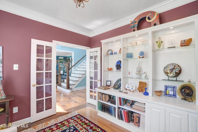 interior space featuring ornamental molding, baseboards, french doors, and wood finished floors
