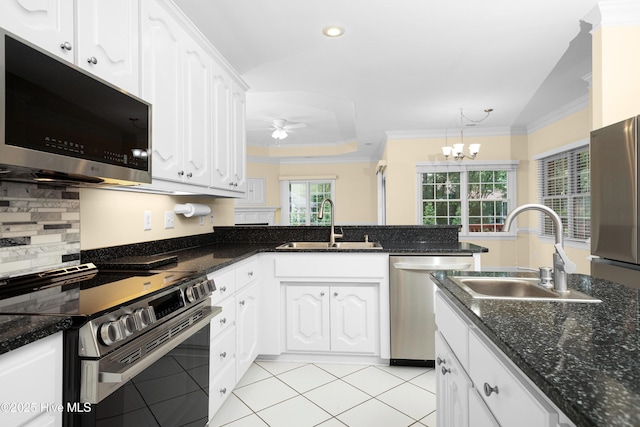 106 Oakmont Cir, New Bern, NC 28562 - kitchen featuring appliances with stainless steel finishes, crown molding, white cabinets, light tile patterned flooring, and a chandelier