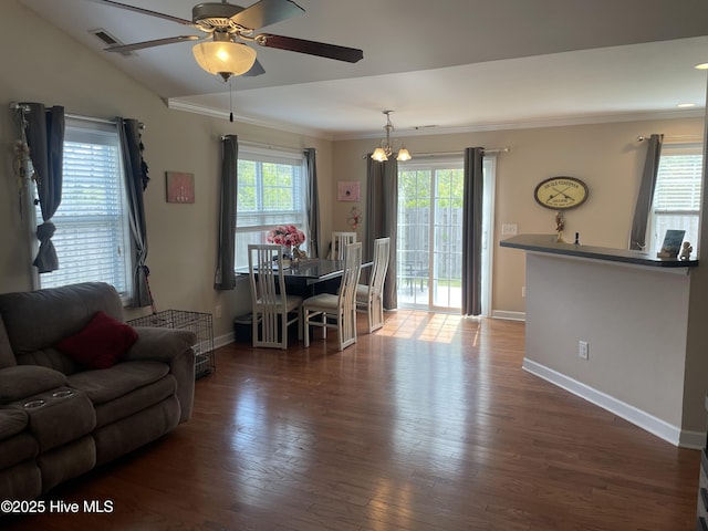 living area featuring baseboards, ornamental molding, ceiling fan, and wood finished floors