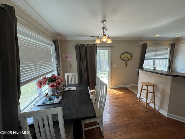 dining room with wood finished floors, baseboards, a chandelier, ornamental molding, and recessed lighting