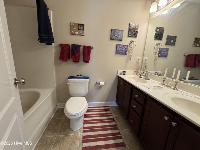 full bath featuring double vanity, a sink, tile patterned floors, and toilet