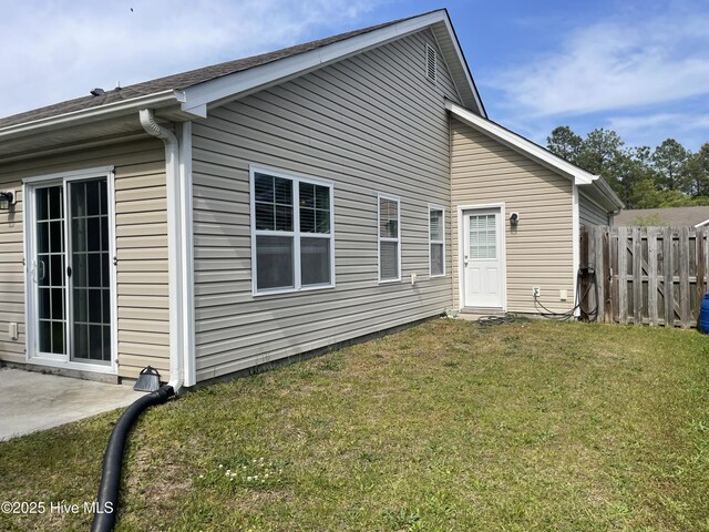 back of house with a lawn, fence, and a patio