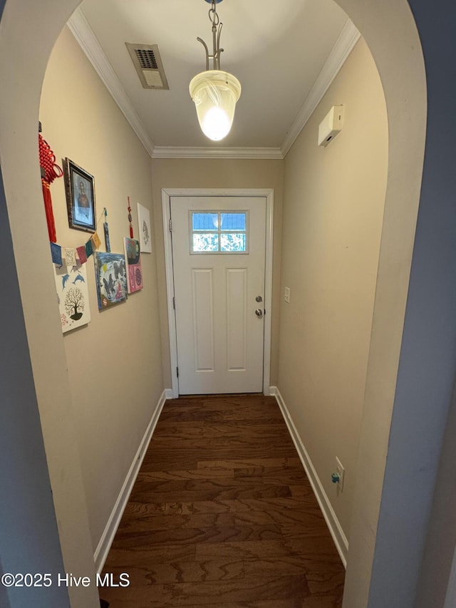 entryway featuring visible vents, crown molding, baseboards, arched walkways, and dark wood finished floors
