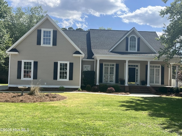 view of front of property with a front lawn, a shingled roof, and covered porch