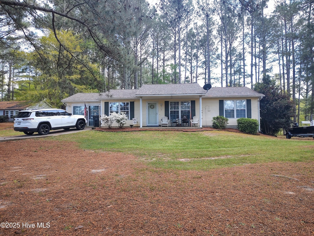 single story home with a front yard, a shingled roof, covered porch, and a chimney