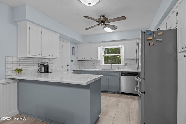 307 Little Rossie Rd, New Bern, NC 28560 - kitchen featuring appliances with stainless steel finishes, ceiling fan, backsplash, a sink, and a peninsula