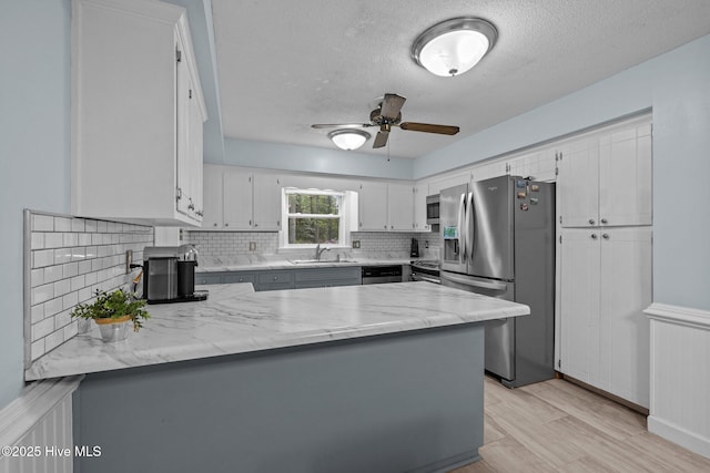 307 Little Rossie Rd, New Bern, NC 28560 - kitchen with decorative backsplash, stainless steel appliances, a textured ceiling, a sink, and a peninsula