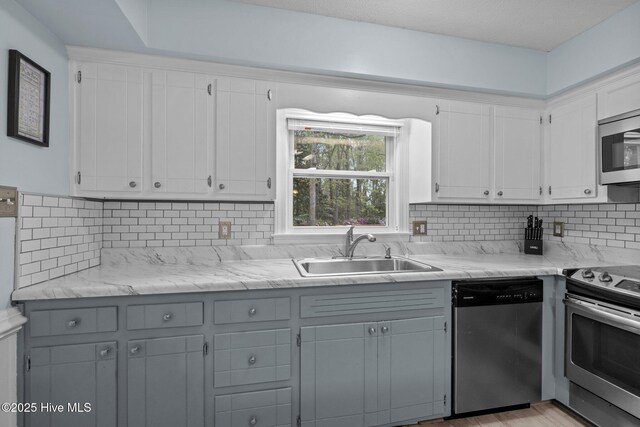 307 Little Rossie Rd, New Bern, NC 28560 - kitchen with backsplash, a sink, white cabinets, and appliances with stainless steel finishes
