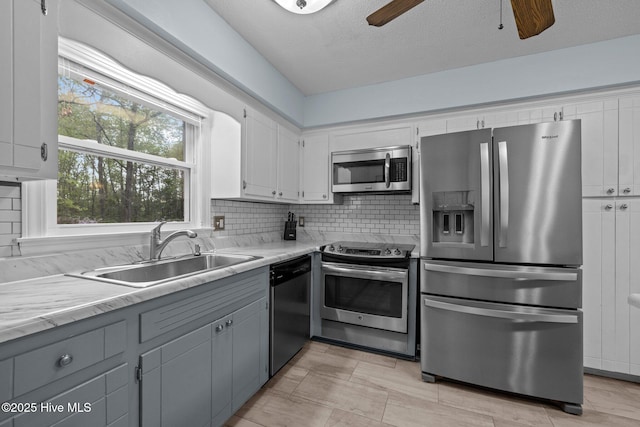 307 Little Rossie Rd, New Bern, NC 28560 - kitchen featuring a sink, stainless steel appliances, gray cabinets, a ceiling fan, and backsplash