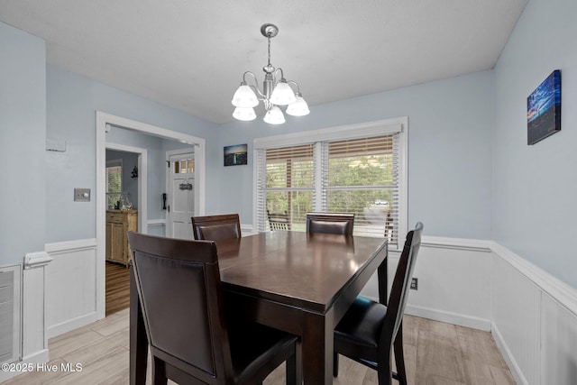 307 Little Rossie Rd, New Bern, NC 28560 - dining space featuring light wood-style flooring, a wealth of natural light, a wainscoted wall, and a notable chandelier