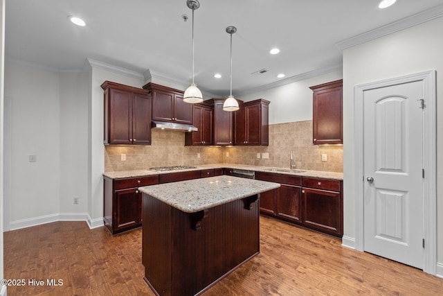 80 Whistling Straight Rd, Pinehurst, NC 28374 - kitchen featuring stainless steel gas stovetop, a kitchen island, wood finished floors, light stone counters, and tasteful backsplash