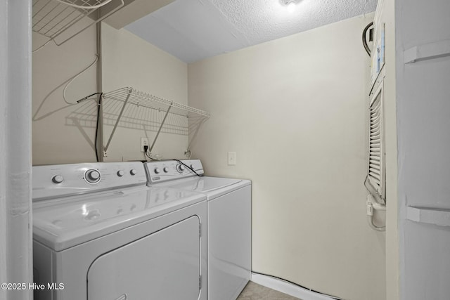washroom with laundry area, washing machine and clothes dryer, and a textured ceiling